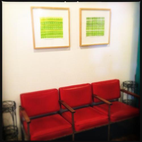 green drawings by the red chairs